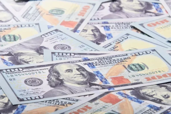 A detailed close-up of 100 US dollar bills showcasing Benjamin Franklin's portrait.