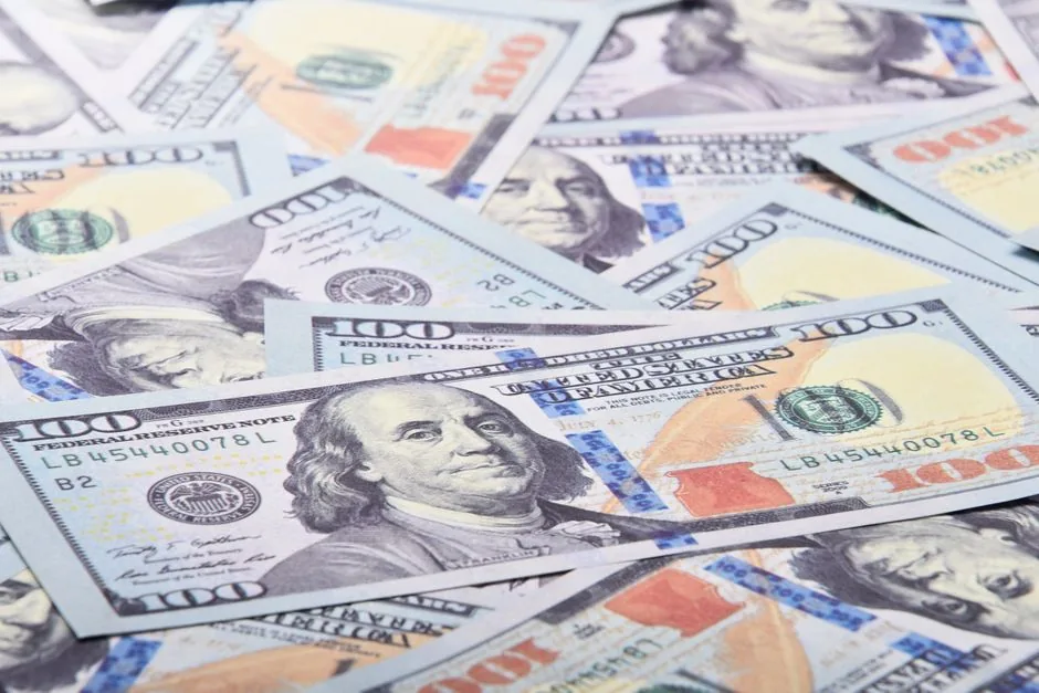 A detailed close-up of 100 US dollar bills showcasing Benjamin Franklin's portrait.
