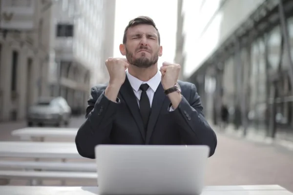 Confident businessman in Budapest celebrates success with a fist pump, reflecting a professional achievement.